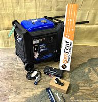 Overview of DuroMax generator with GenTent box, remote, tools, hose, funnel, oil, and cable arranged on wooden floor