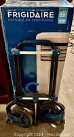 Boxed Frigidaire unit on folded handcart