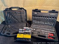 Photo showing three tool cases open containing socket sets, ratchets and a Klein Tools hex bit holder with bits, displayed on a surface