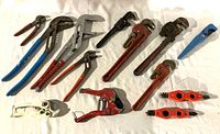 Overview of all plumbing tools including wrenches, pliers, cutters, and brushes on white background.