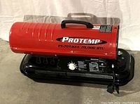 Full side view of red ProTemp PT-70T-KFA kerosene heater with black base, featuring ProTemp logo and model name with BTU output visible.