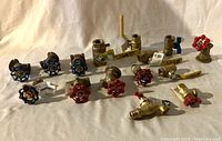 Set of 15 brass plumbing valves including shutoffs with red and blue butterfly handles, lever ball valves with yellow levers.