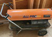 Side view of the orange All-Pro forced-air heater on sled with handle and wheels.