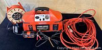 Front view of Black & Decker Electromate 400 unit, cordwinder, charger, and extension cord coiled on side