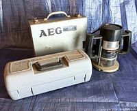 Three power tools shown including Black & Decker router, Black & Decker metal case likely housing the angle grinder, and a Dremel rotary tool case.