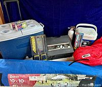 Wide view showing the camping cooler items, stove case, walkie-talkies, canopy bag, and sleeping bag.