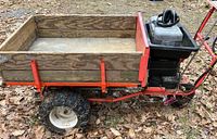 Side profile of red frame cart with wooden bed and black tray mounted at front
