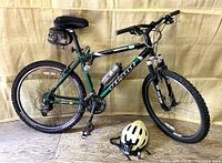 Full side view of the Giant Iguana SE mountain bike with helmet and seat bag.
