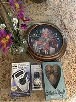 Lot contents showing Santa-themed clock, crank radio, wristwatch, vase with flowers, and wooden plaque.