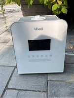 Front view of the Levoit humidifier showing digital display, brand logo, and control buttons.