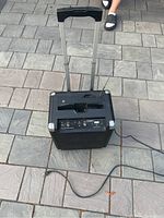 Full view of ION Block Rocker Bluetooth boombox from the back/top showing telescoping handle extended, power cord, and speaker grille.