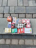 Top-down photo showing entire assortment of light bulbs and packaging on pavement.