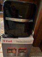 Front view of T-fal Easy Fry Oven & Grill unit atop its original box.