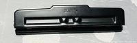 Black Bates paper puncher shown from top angle, displaying the punching mechanism.