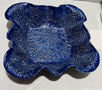 Top-down view of the navy blue ceramic table centrepiece bowl showing the textured geometric pattern inside and wavy edges.