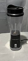Full view of black Hamilton Beach personal blender with transparent jar attached and lid in place.