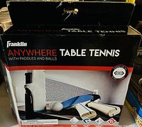 Box of Franklin Anywhere Table Tennis including paddles, net, posts, and balls