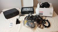 Lot staged to show all items: Canon camera, Sony CD player, digital picture frame, remote extender base, various cables and wires.