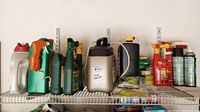 Full view of shelf with assorted lawn and pest control chemicals in bottles and spray cans.