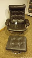 Front view of brown tufted reclining swivel chair and matching ottoman