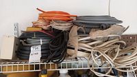 Shelf with multiple spools and coils of electric wiring, various colors and sizes; includes boxed and loose coils