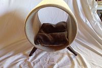 Front view of cylindrical cat bed on wood legs