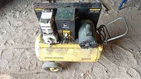 Full view of yellow John Deere B200 air compressor on wheels