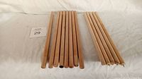 Thirteen wooden dowels arranged by length