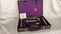 Open case showing hardness tester, microscope, three test bars, ball holder