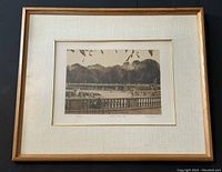 Framed lithograph showing park scene with people and tree backdrop.