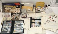 Overview of collection showing stamp albums, envelopes, and boxes containing stamps from various countries and eras