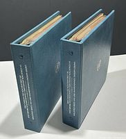 Two light blue binders standing upright showing spines with white printed text 'United Nations Commemorative First Day Cover Collection'. Each binder measures approximately 10 x 2 x 9 inches.
