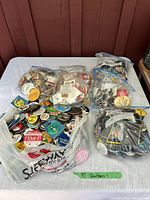 Overview photo showing multiple bags with numerous collectible pins.