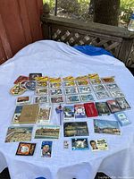 Wide view of the entire card collection laid out on a white sheet on a table