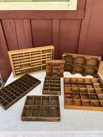 Photo showing all seven wooden miniature storage items arranged on a fabric surface against a wooden wall background.