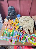 Full lot view showing Millennium Falcon, Darth Vader bust, rubber ducks, PEZ dispensers, speeder vehicle, and cup