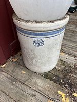 Full view of the large number 12 stoneware crock showing size and dirt condition