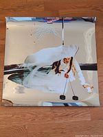 Reflective aluminum sheet poster featuring artistic image of person in white, showing the front with artwork.