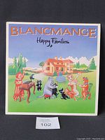 Front cover of Blancmange Happy Families vinyl LP showing colorful illustrated cats around a cake in a garden