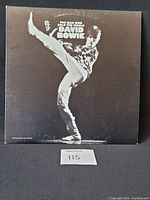 Front cover of vinyl LP album The Man Who Sold The World by David Bowie, showing Bowie in a dynamic kicking pose in black and white.