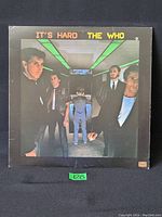 Front side of The Who 'It's Hard' vinyl LP album cover showing band members under ceiling lights.