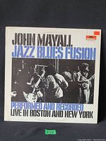 Front cover of 'Jazz Blues Fusion' Vinyl LP by John Mayall with photo of live performance and title text.