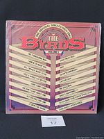 Front cover of The Byrds The Original Singles 1965-1967 Volume 1 vinyl LP showing track titles and colorful artwork.