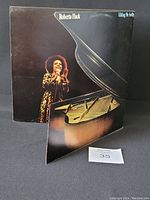 Front cover of Roberta Flack's "Blue Lights in the Basement" vinyl LP showing artist and a grand piano with album title and artist name.