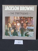 Front cover of Jackson Browne 'The Pretender' vinyl LP album showing people walking in a street scene.