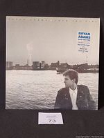 Front cover of Bryan Adams 'Into the Fire' vinyl album showing cityscape and Bryan Adams profile.