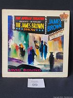 Front cover of James Brown 'Live' At The Apollo vinyl LP showing colorful painted urban scene and typography.
