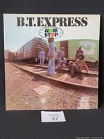 Front cover of B.T. Express Non-Stop vinyl LP showing band members at train tracks with 'Non-Stop' logo and band name on top.