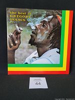 Front cover of 'The Best of Gregory Isaacs' vinyl LP showing colored portrait of Gregory Isaacs smoking with green, yellow, and red border