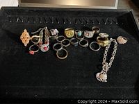 Photo showing all rings and bracelets spread out on black fabric background